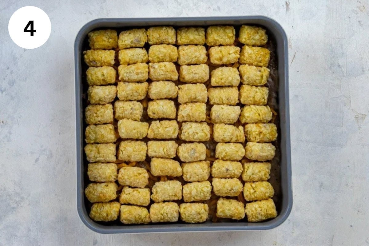 Frozen tater tots placed on top of the beef mixture and cheese.